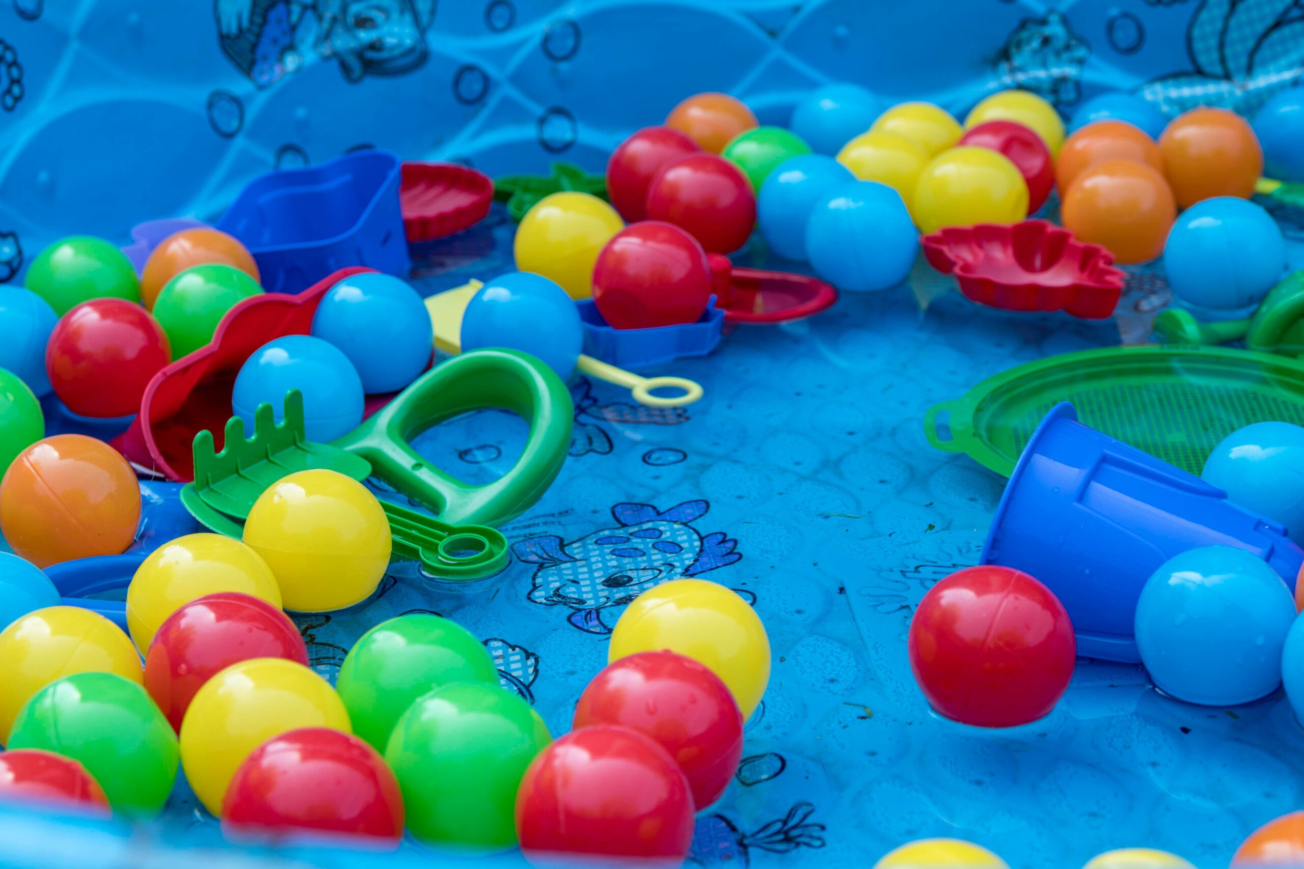 Ball-pit balls and toy spades lie in an paddling-pool with nobody playing in it, representing the perk-cession. Image by Christine Tutenjian on Unsplash. Thanks Christine.